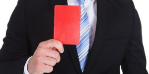 Man in suit holding a red card
